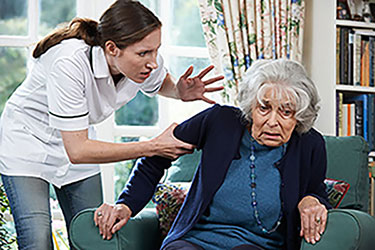 nurse yelling at old woman sitting on chair