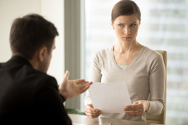 women holding paper looking suspicious while man explains