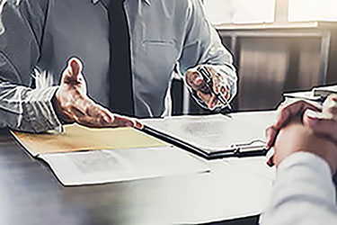 personal injury case man talking to another person at a desk with papers in front of them