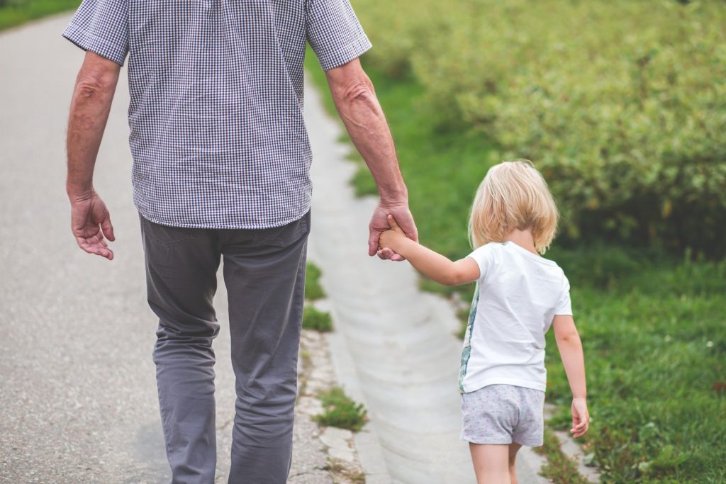 dad and child walking hand in hand