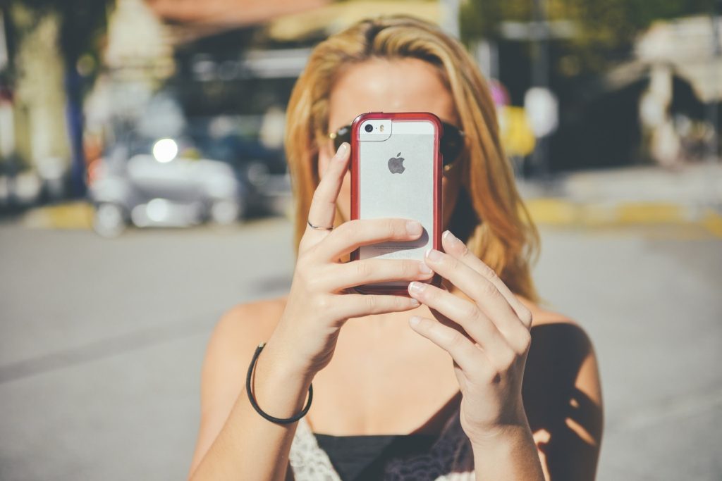 Woman with phone taking photos of an accident or an injury