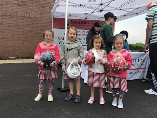 photo of four girls standing beside the hard headed kids program sign holding helmets