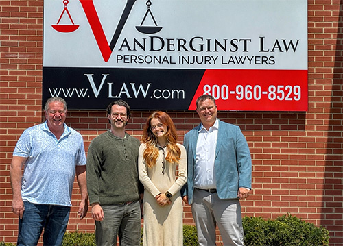 Dennis, Nick, Lindy, Ben standing together in front of VanDerGinst Law Building In Des Moines